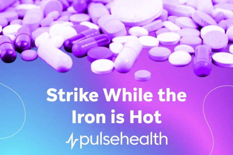 Assorted capsules and tablets scattered over a blue-to-purple gradient background with the text “Strike While the Iron Is Hot” and the Pulse Health logo.