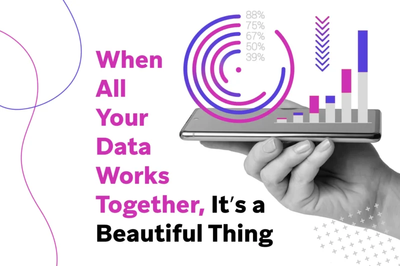 Hand holding a smartphone displaying overlayed circular and bar charts with the text “When All Your Data Works Together, It’s a Beautiful Thing.”